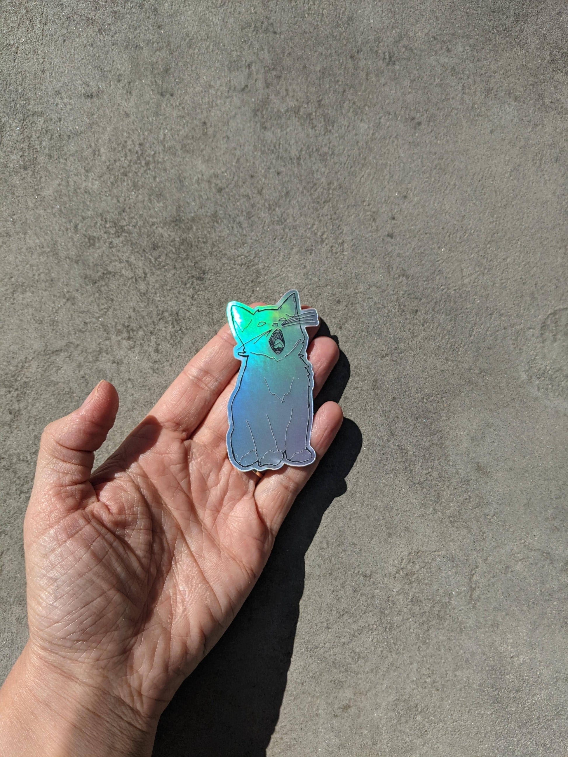 Holographic yawning kitten sticker.